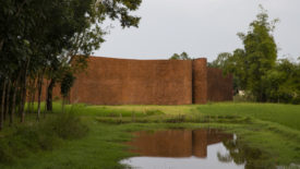 an undulated brick wall in a rural landscape
